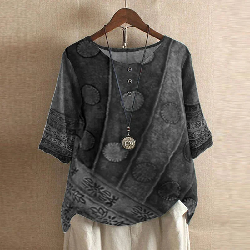 Women’s abstract floral blouse, dark gray with patterned motifs, short sleeves.