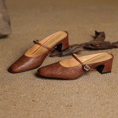Pair of brown embossed leather mules with square toe, buckle strap, and block heel