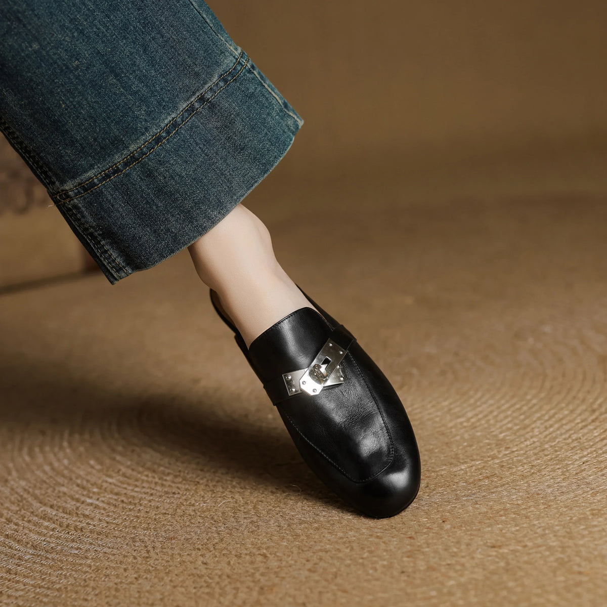 Black leather mule slip-on with square toe and metallic buckle strap
