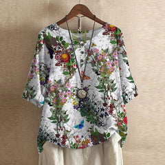 Women’s white botanical blouse with red, pink, and green floral print, button-front, short sleeves.
