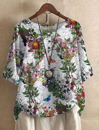Women’s white botanical blouse with red, pink, and green floral print, button-front, short sleeves.