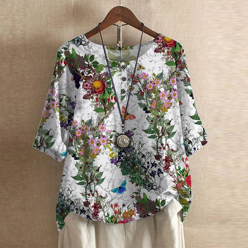 Women’s white botanical blouse with red, pink, and green floral print, button-front, short sleeves.