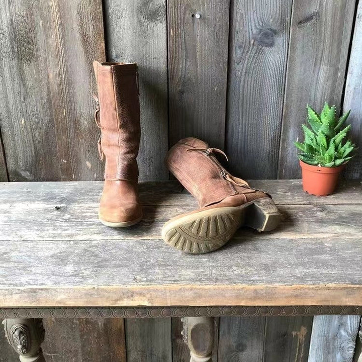 Brown tall boots with side zipper; visible tread sole and curved cuff