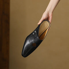 Black leather mule with round side cutout and stud ornament, low heel