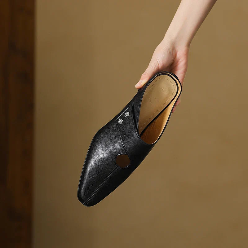 Black leather mule with round side cutout and stud ornament, low heel