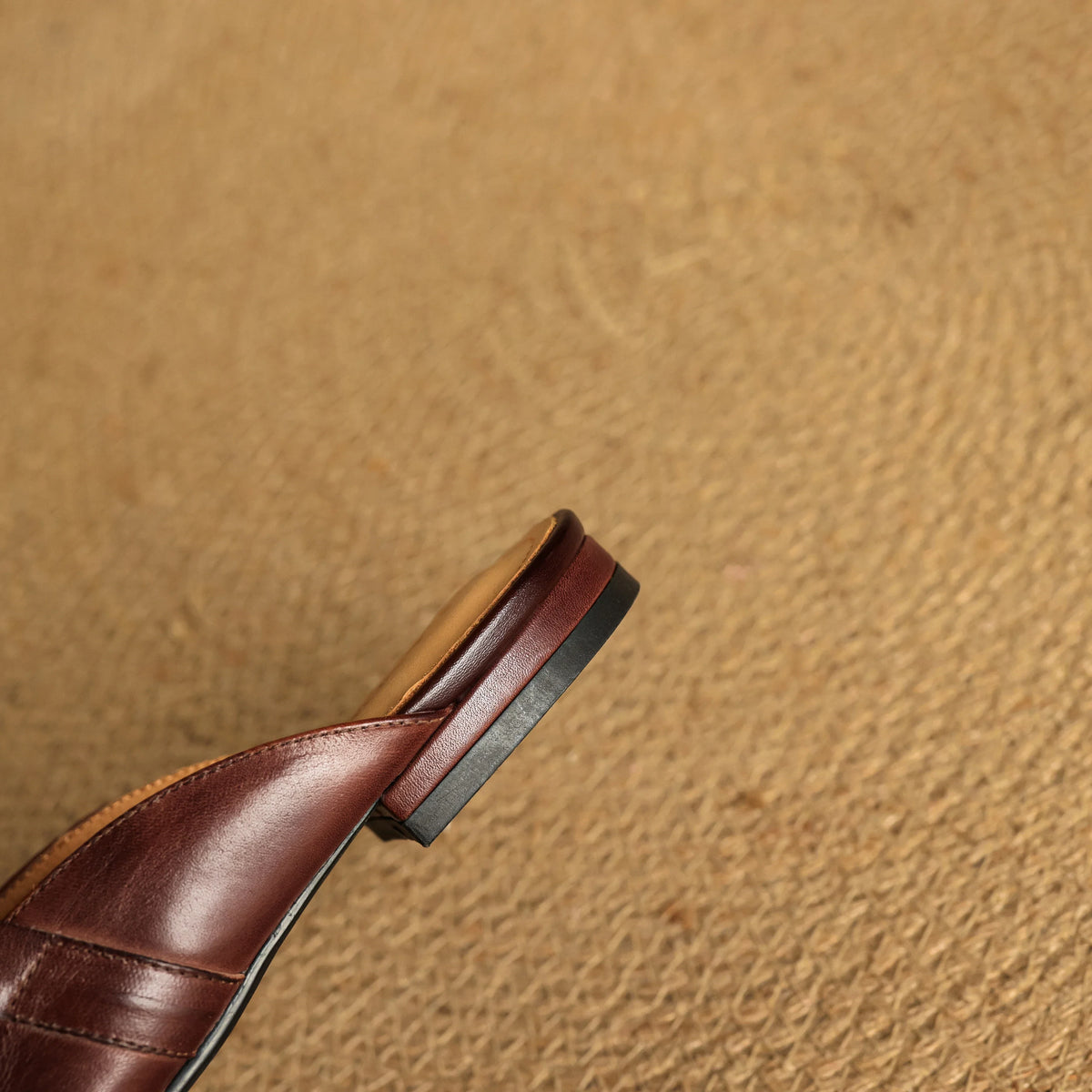 Maroon leather mule strap detail with low heel and dark sole