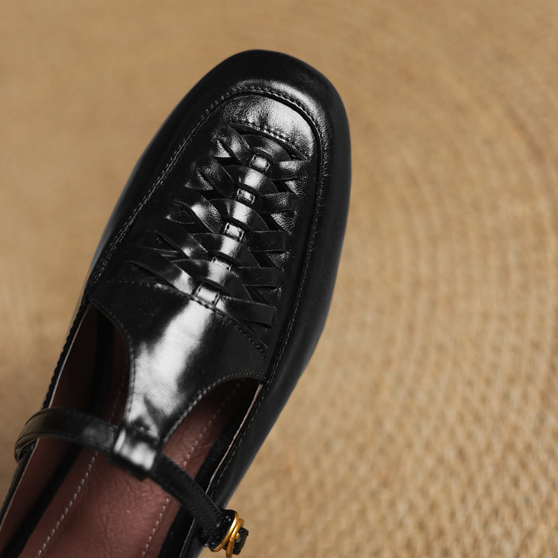Close-up of black leather mule with braided lace-up vamp and low heel