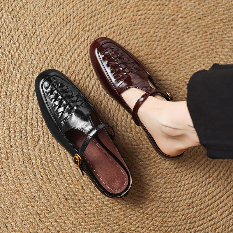 Black and brown leather mules with braided vamp, sling strap, and gold buckle