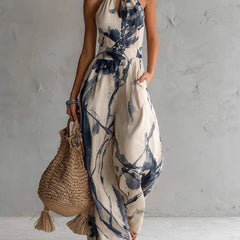 Blue ink-wash halter jumpsuit, sleeveless wide-leg with neck tie and elastic waist.