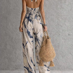 Ink-wash halter jumpsuit with open back neck-tie and wide-leg pant silhouette.