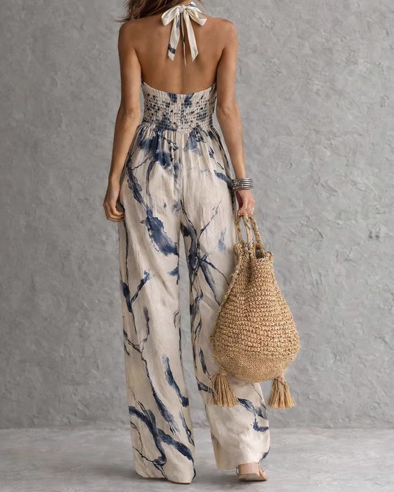 Ink-wash halter jumpsuit with open back neck-tie and wide-leg pant silhouette.