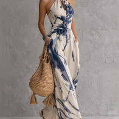 Blue ink-wash halter jumpsuit with neck tie, sleeveless bodice, and flowing wide legs.