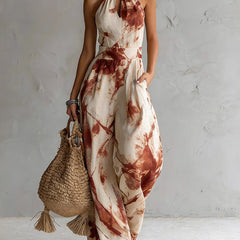 Red ink-wash halter jumpsuit with sleeveless wide legs, neck tie, and elastic waist.