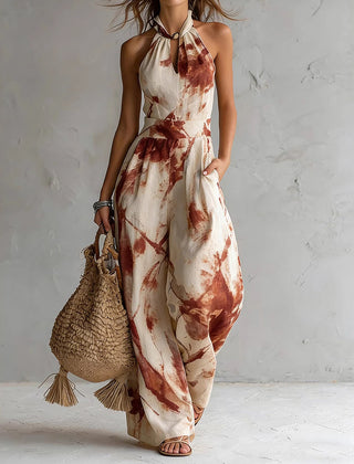 Red ink-wash halter jumpsuit with sleeveless wide legs, neck tie, and elastic waist.