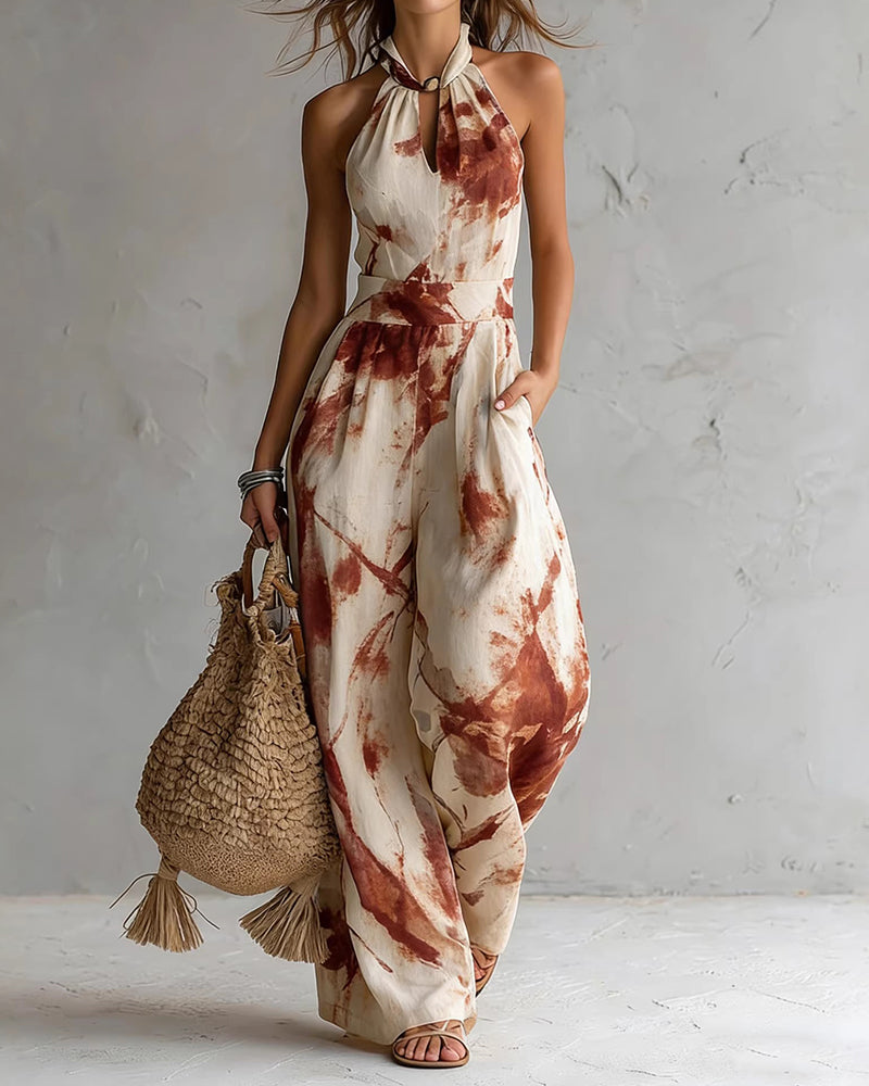 Red ink-wash halter jumpsuit with sleeveless wide legs, neck tie, and elastic waist.