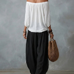 White off-shoulder top and black draped harem pants resort set, back view