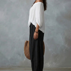 White off-shoulder top and black draped harem pants resort set, side view