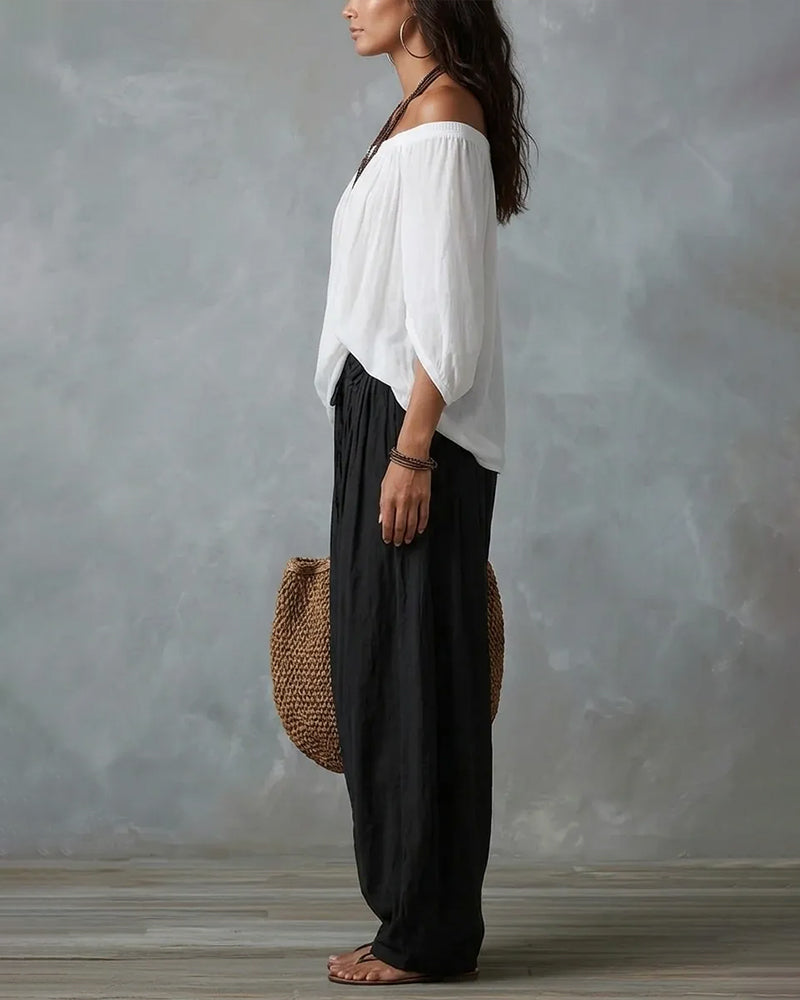 White off-shoulder top and black draped harem pants resort set, side view