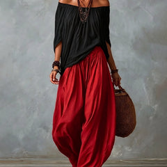 Black off-shoulder top and red draped harem pants resort set with wide neckline