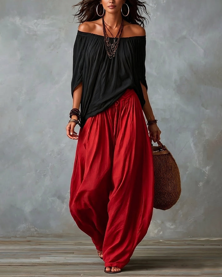 Black off-shoulder top and red draped harem pants resort set with wide neckline