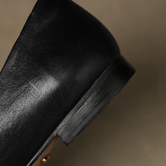 Black leather flat with stacked-look heel and visible stitched edge