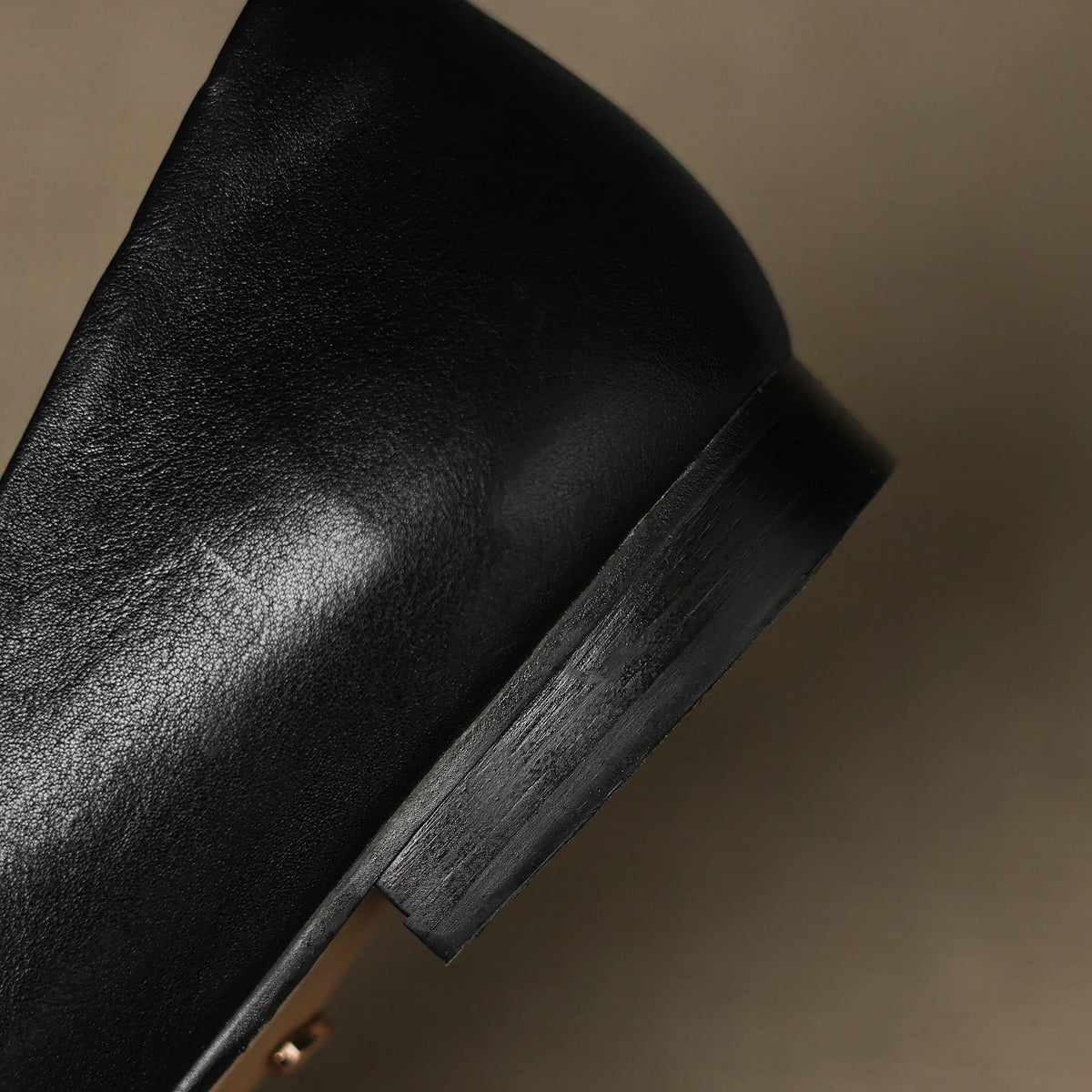 Black leather flat with stacked-look heel and visible stitched edge