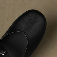 Black leather flat with smooth rounded toe and curved topline seam