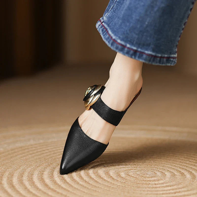 Black leather heeled mule with pointed toe and rosette buckle ankle strap