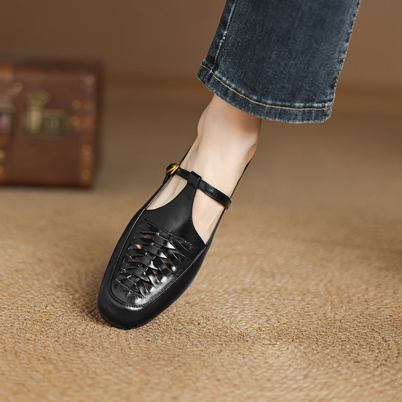 Black leather mules with braided detail, lace-up front, and low black heel