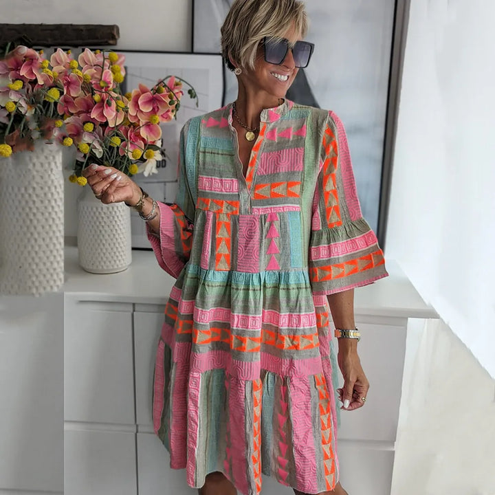 Boho spring dress three-quarter view with tiered skirt and geometric pattern in teal and pink