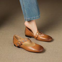 Tan leather flats, low-profile buckle strap with star-flower ornament detail