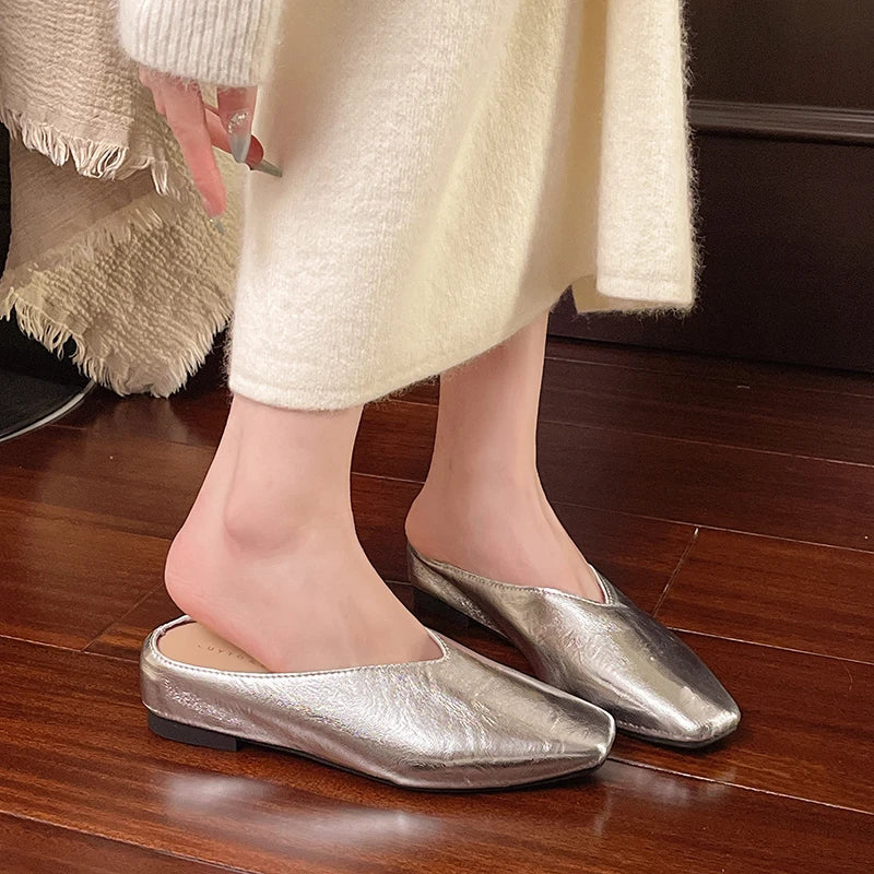 Silver metallic pointed-toe mules with low block heel, on-foot view