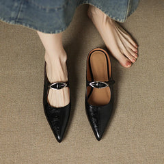 Pair of black leather mules with pointed toe and shiny buckle slingback strap