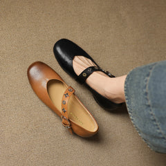 Khaki and black leather flats with patterned strap and buckle details