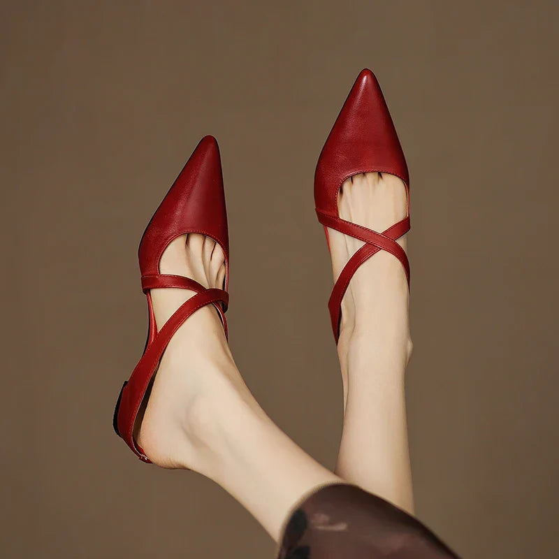 Red leather mules with pointed toe and slingback strap, low heel, front view.