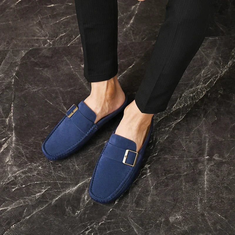 Blue suede mules with square buckle strap and moc-toe stitching