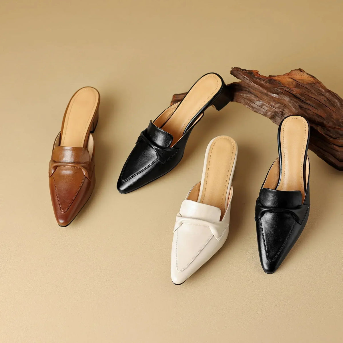 Leather mules in tan, black, and white with pointed toe and low block heel.