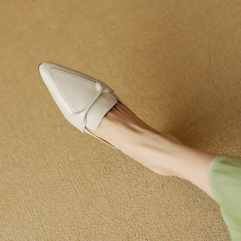 Beige mule on foot, pointed toe and slip-on V strap, angled view