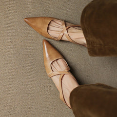 Tan leather mules with pointed toe and slingback strap, low heel detail view.