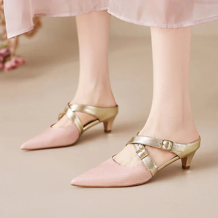 Pink textured leather mule sandals with pointed toe, gold straps, and low block heel.