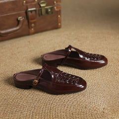Two brown leather mules side view with braided upper and round gold buckle