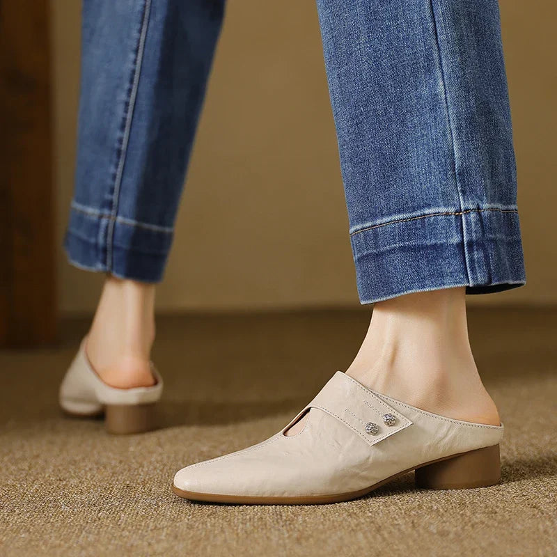 Beige leather mules with pointed toe and small stud detail on the vamp