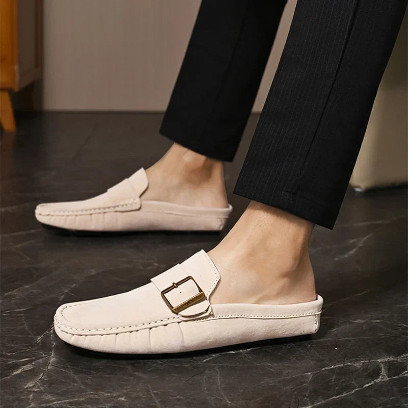 Cream suede mules with square buckle strap, moc toe, and low profile