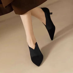 Black suede pointed-toe heeled pumps with slim heel and slip-on upper