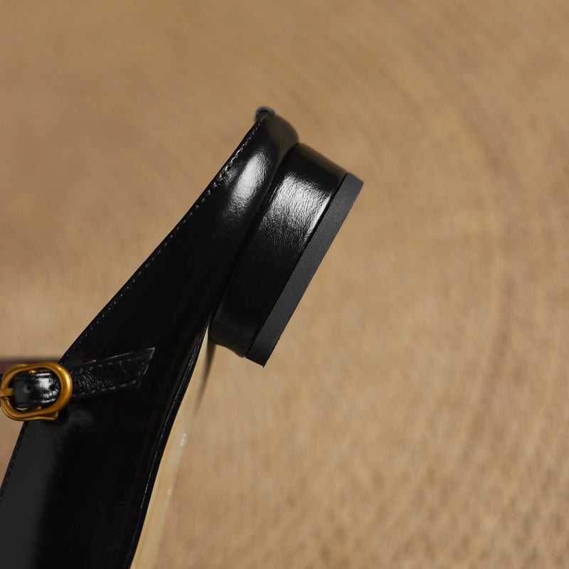 Black leather mule heel and strap hardware detail with stacked low heel