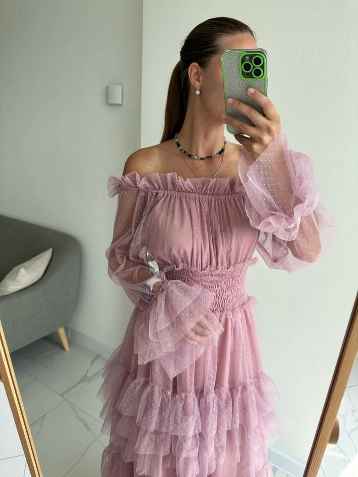 Pink sheer off-shoulder tiered ruffle dress on model, smocked bust