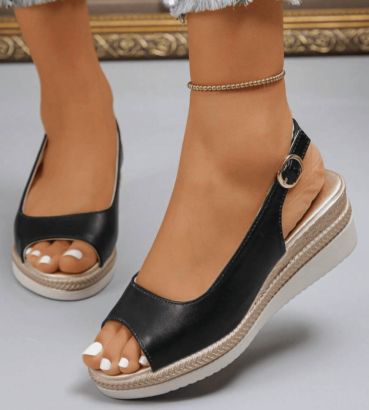 Black orthopedic sandals with open toe and ankle strap buckle, cushioned wedge platform.