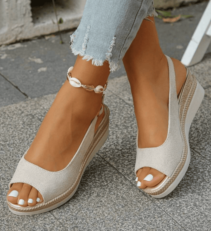 Light gray orthopedic sandals with open toe, ankle strap buckle, textured wedge sole.