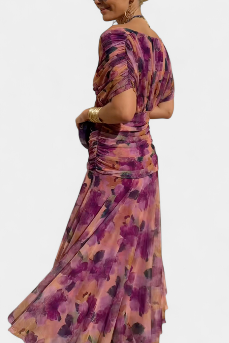 Purple patterned draped maxi dress with fitted waist and fluttering skirt, side view