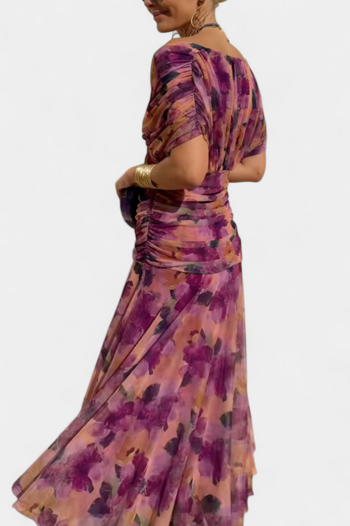 Purple patterned draped maxi dress with fitted waist and fluttering skirt, side view